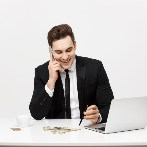 Concentrated young businessman writing documents at office desk