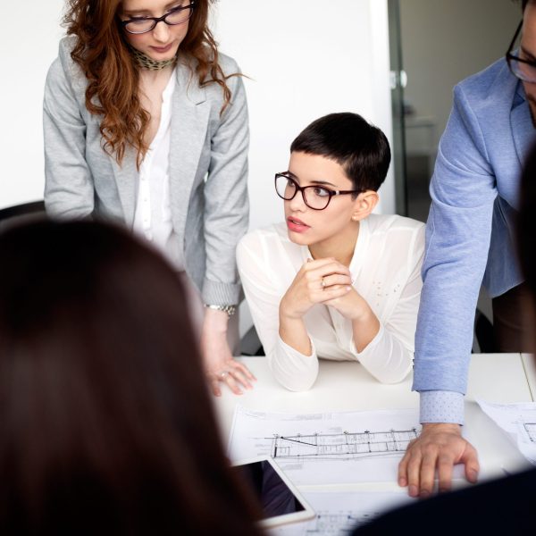 Group of lawyers in suits discussing contract together in office